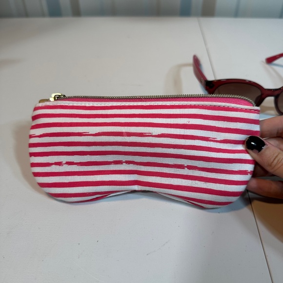 Pink women’s Lacoste sunglasses with pink striped carrying pouch